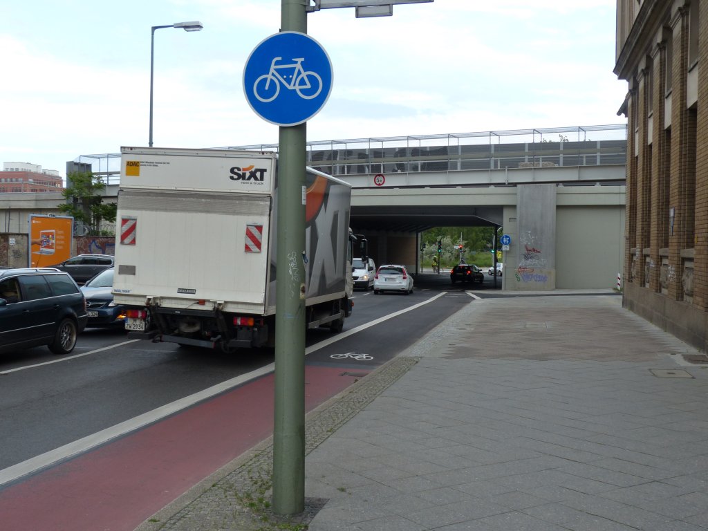 Einf�delung des Radwegs in die Fahrbahn: Stralauer Allee in Blickrichtung Osten. Normalerweise widerstrebt es dem Selbsterhaltungstrieb, schr�g in den schnelleren, von hinten kommenden Flie�verkehr einzufahren. Das soll nun wirklich besser sein als Mischverkehr oder ein durchg�ngiger Fahrradstreifen, der auch in der Engstelle besteht? Von allen Optionen (kein Radweg, durchg�ngiger Radweg) hat man hier wohl die schlechteste gew�hlt. 3.6.2013