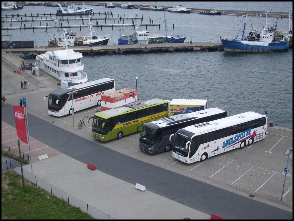 Setra 415 HDH vom Reisebro Buck aus Deutschland und Setra 415 GT-HD von Wricke-Touristik aus Deutschland und VDL Futura aus Deutschland und MAN Lion's Coach von Melskotte aus Deutschland im Stadthafen Sassnitz. Dank dem Hngerzug stehen  die drei schief in der Parklcke.