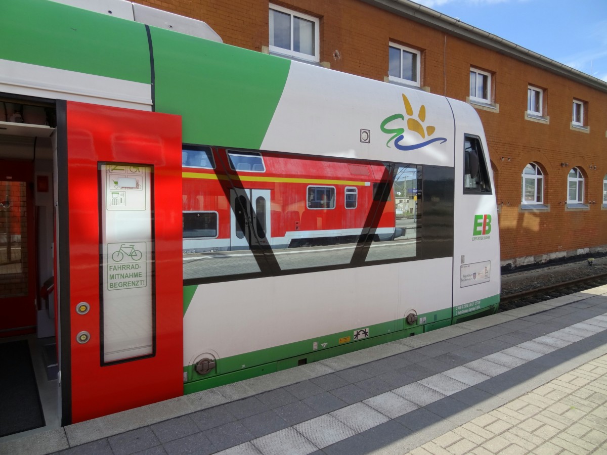 Blick auf einen Triebzug der Baureihe 650 in dessen Fenster sich ein DR-Doppelstockwagen spiegelt.
Aufgenommen im August 2014 in Saalfeld(Saale).