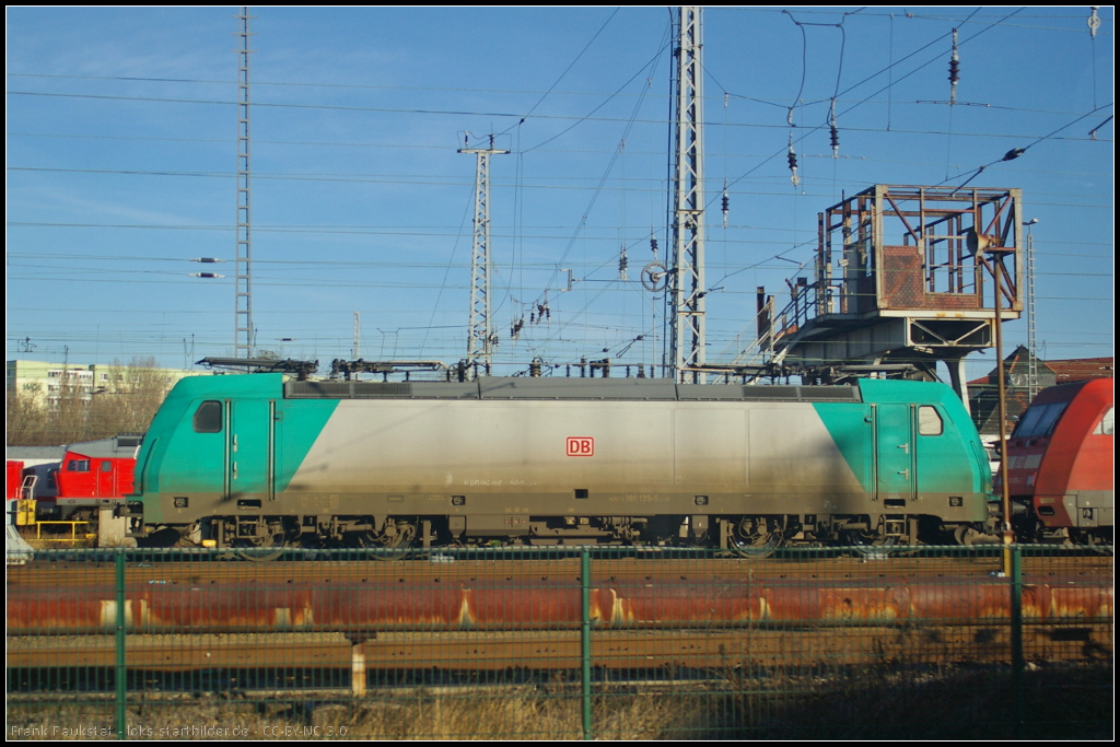 DB Fernverkehr 186 135 am 07.01.2014 in Betriebswerk Berlin-Rummelsburg abgestellt. In den Schmutz hat jemand  Komische Lok  geschrieben (fotografiert aus vorbeifahrenden Regio)