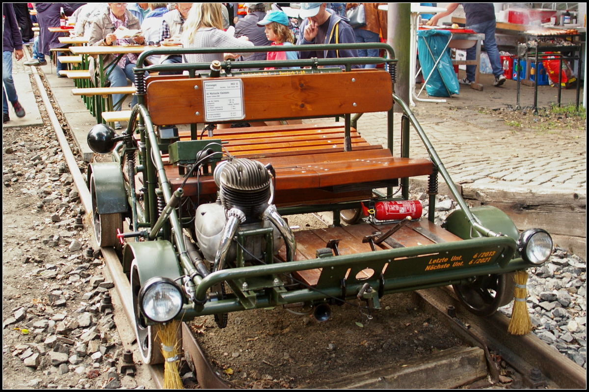 Die Motordraisine stammt aus dem Fuhrpark der MAV und kam dann in den Besitz eines Vereinsmitglieds der AG Märkische Kleinbahn e.V., der diese 2003 dem Verein schenkte. Ursprünglich besaß sie eine andere Lackierung und ein Windschild mit Spitzenlicht, das aber nicht Bautypisch war. So entschloss man sich die Draisine in den Urzustand zu versetzen. Als kleine Auffälligkeit zeigen sich die Reisigbesen vor jedem Rad um die Schiene zu säubern. Zu sehen war die Draisine am 10.09.2017 während des Tag der offenen Tür am 10.09.2017 in Berlin-Lichterfelde