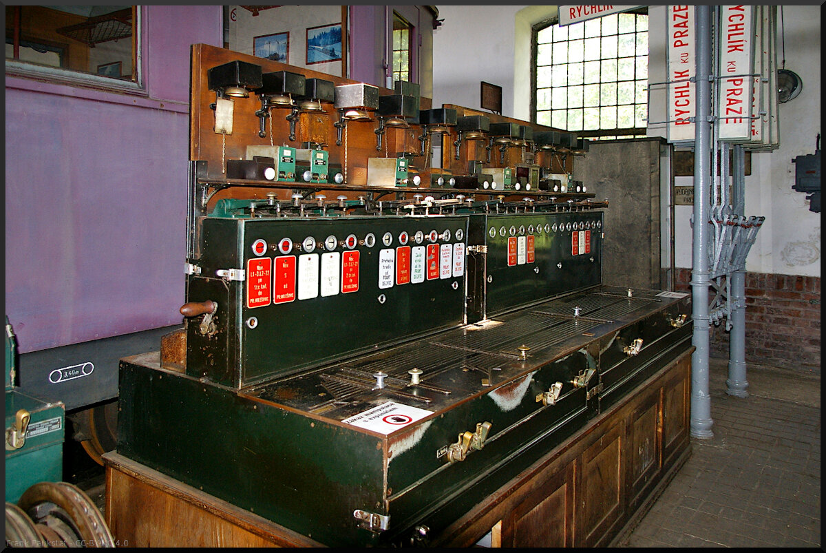 Dieser alte Stellwerkstisch steht im Lokschuppen vom Eisenbahnmuseum Jaroměř. Die Fahrstraßen werden hier mechanisch mit Schiebern eingestellt, die Rückmeldungen erfolgen über Glocken. Leider war nicht zu erfahren welcher Bauart und welches Baujahr der Tisch ist. Es hapert dann doch an der Sprache.

Jaroměř, 21.05.2022
