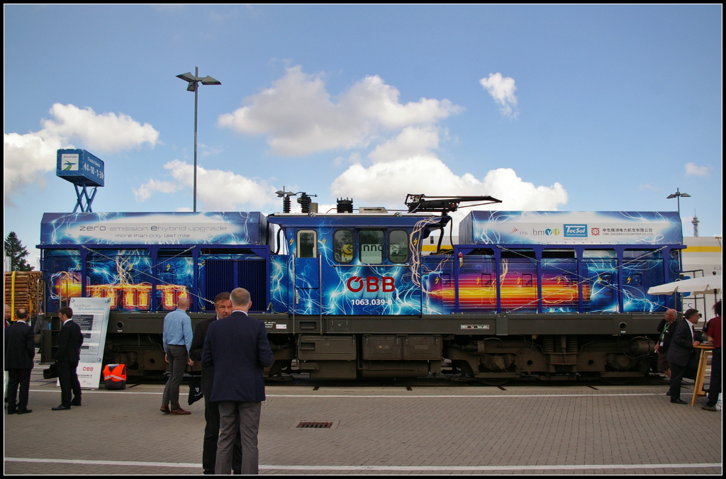 InnoTrans 2016 in Berlin: Die neue komplett emissionsfreie Rangierlokomotive der ÖBB. Sie wurde von der Firma TechSol GmbH entwickelt und ist als Baureihe 1063 eingereiht. Die Lackierung der Lok zeigt wie sie angetrieben bzw wie die Versorgung mit Elektrizität funktioniert. Zum einen kann sie normal unter Fahrtdraht betrieben werden, gleichzeitig werden dann die Akkupacks geladen und sie kann auch nur mit Akku fahren. Eingesetzt werden die Loks im Rangierdienst, an Ablaufbergen und zu Übergabefahrten.