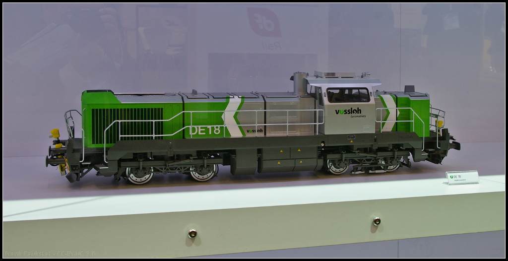 Model of Vossloh DE 18 diesel electric locomotive.
<br /><br />
Bei der DE 18 von Vossloh handelt es sich um eine Lokomotive fr den Frachtverkehr. Die Lok bietet eine Leistung von maximal 1800 kW und eine Start-Stopp-Automatik (VED) sowie ein Fahrer-Assistenzsystem. Zuknftig sollen auch Hybrid- und Speichertechnik mglich sein. Das Modell war whrend der InnoTrans 2014 n Berlin am Messestand von Vossloh ausgestellt.
<br /><br />
Webseite Daten (deutsch): http://www.vossloh-locomotives.com/de/products_and_services/diesel-hydraulic_locomotives/de12_de18/de12_de18.html
