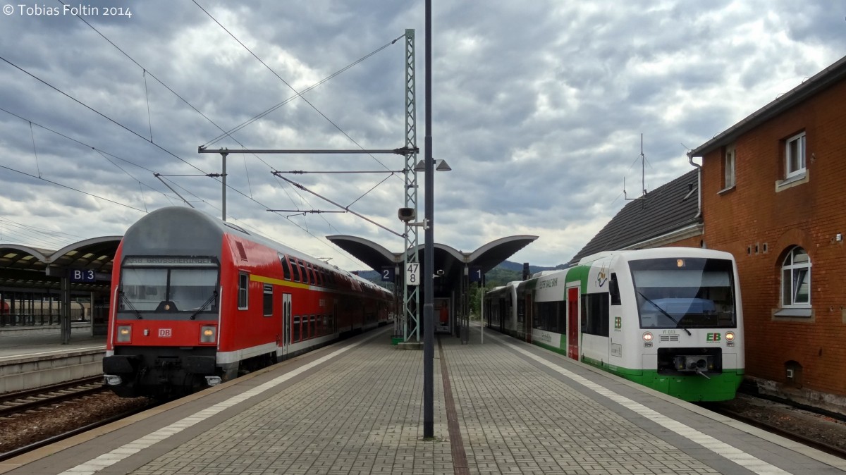 Rechts steht ein 650er der ErfuterBahn über Erfurt nach Apolda und links eine DR-Doppelstockwagen Garnitur nach Großheringen.
Aufgenommen in Saalfeld im August 2014.