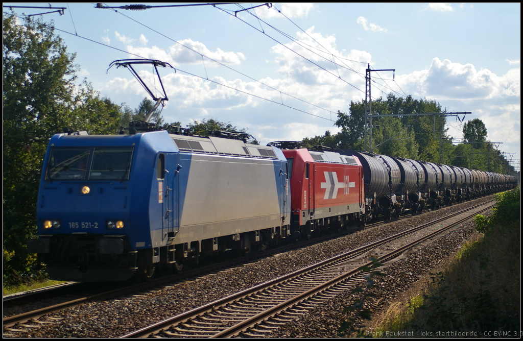 RheinCargo 185 521-2 und Wagenlok 185 604 mit Knickkesselwagen-Zug am 11.08.2014 durch Panketal-Rntgental