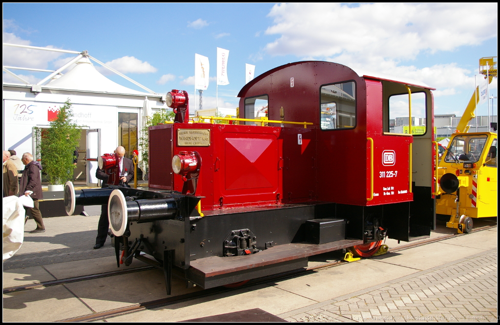 Seit 1889 kann die Firma Windhoff auf Kompetenz in den Bereichen Schienenfahrzeuge, Bahn- und Rangiertechnik zurückschauen. Heute ist die Firma breit aufgestellt und bietet Produkte für Haupt- und Nebenbahnen, Nahverkehr und Metro, Bau und Instandhaltung von Gleisanlagen, Frachttransport, Lösch- und Rettungsfahrzeuge an. Der Oldie DB 311 225-7 stand als Vertreter für Dieselrangierloks von Winhoff auf der InnoTrans 2014 in Berlin auf dem Aussengelände. Ursprünglich wurde die Lok 1936 als Kö 0225 an die DRG ausgeliefert, Ausmusterung erfolgte 1979. Zum DB Museum Nürnberg gelangte die Kleinlok dann 1996
<br><br>
Webseite (deutsch): http://www.windhoff.de/
