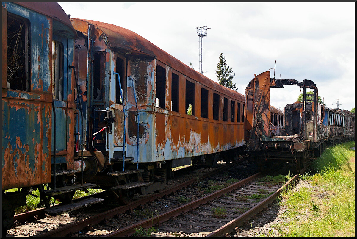 Vandalismus bis zur Brandstiftung ist nicht nur in Deutschland ein Problem. Im Eisenbahnmuseum Jaroměř hat es mehrere Personenwagen durch Brandstiftung zerstört. Der rechte Wagen ist bis auf den Rahmen abgebrannt, der linke Wagen hat sich durch die Hitze komplett verzogen. Auch die jeweiligen dahinter stehenden Wagen wurden stark in Mitleidenschaft gezogen. So sind sie ein Fall für den Verwerter und müssen vor Ort auseinander geschnitten werden.

Jaroměř, 21.05.2022
