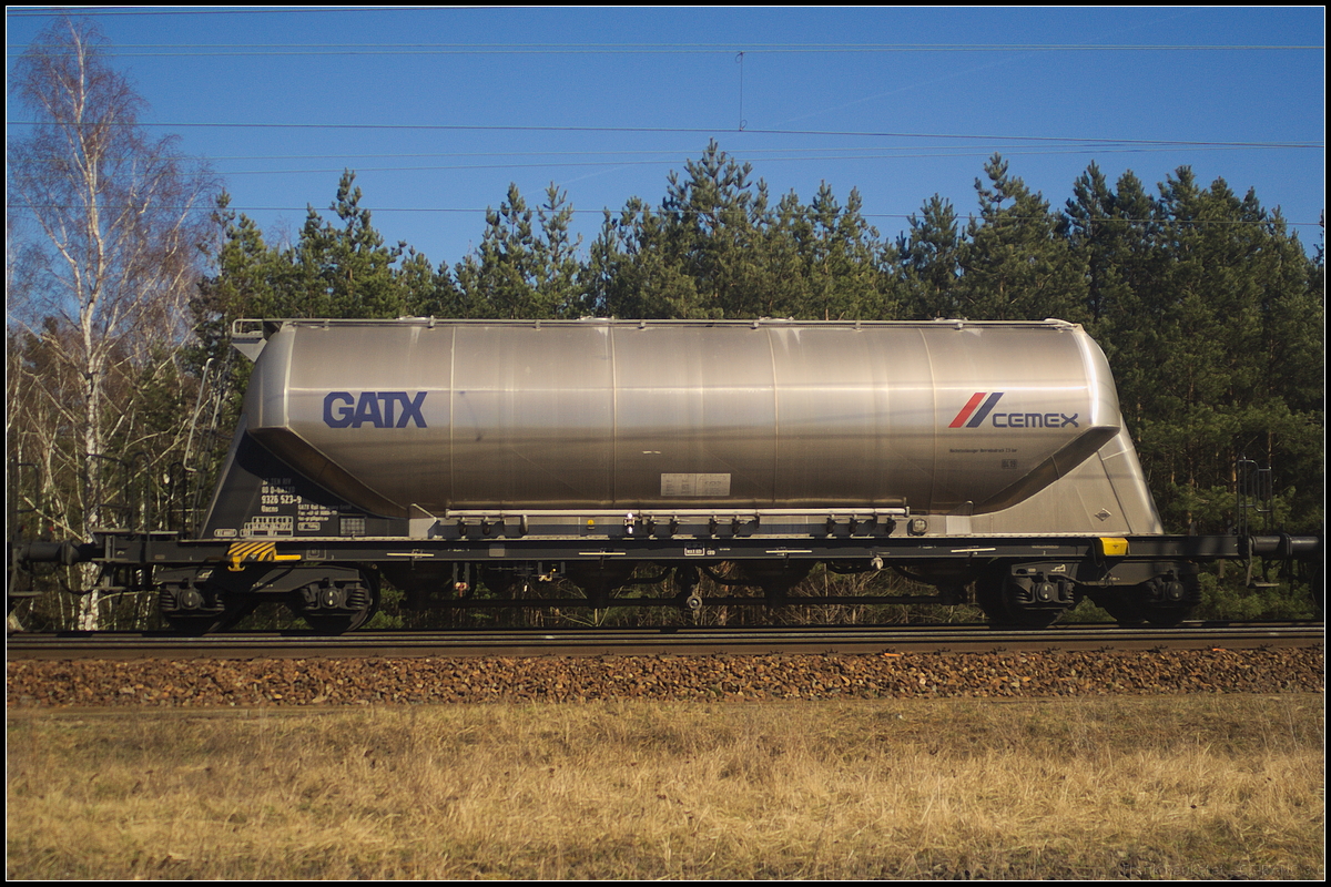 Vierachsiger Drehgestell-Staubgutwagen der Gattung Uacns des Einstellers GATX Deutschland mit Cemex-Logo. Eingereiht war der Wagen in einem Zug weiterer Wagen der am 06.04.2018 durch die Berliner Wuhlheide fuhr (37 TEN RIV 80 D-GATXD 9326 523-9 Uacns)