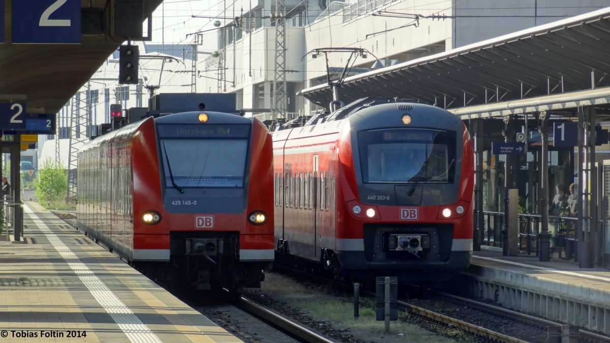 Zwei Züge ein Ziel: Rechts am Gleis 1 steht die RB nach Würzburg und links am Gleis 2 der RE.  
Aufgenommen im April 2014.