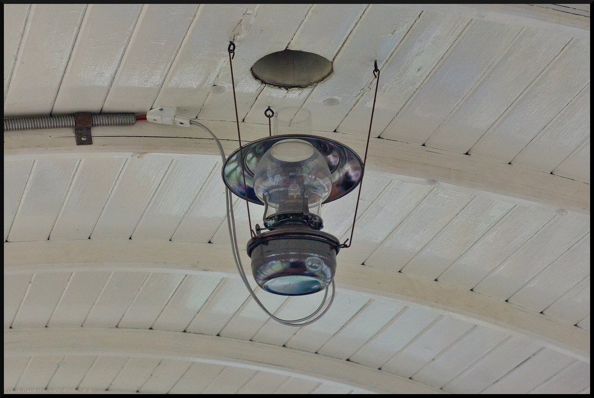 Detailbild der Innenraumbeleuchtung von Wagen 22 (Panoramawagen) der Museumsfeldbahn Leipzig-Lindenau e.V. Wie man sieht war ursprünglich vorgesehen die Lampen mit Petroleum zu betreiben. Damit der Ruß abziehen konnte gab es Öffnung im Dach. Der Umbau auf elektrisches Licht erfolgte im Jahr 2006. Gesehen bei einer Fahrt im Wagen am 29.12.2023.