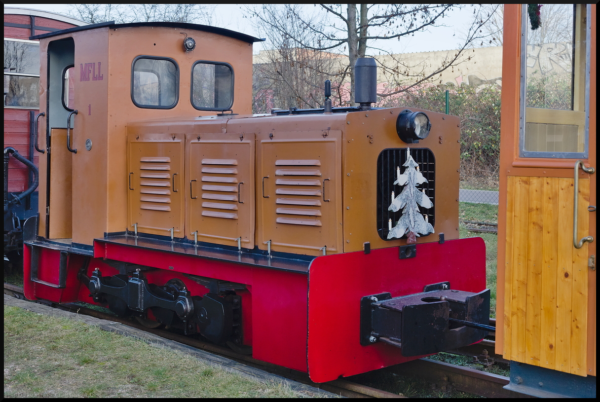 Zwischen zwei Zügen steht Lok 1 der Museumsfeldbahn Leipzig-Lindenau, die noch ihren Weihnachtsschmuck trägt. Die Lok wurde 1954 von LKM Babelsberg gebaut und kam im Jahr 1992 zur Museumsfeldbahn. Sie wird bei Veranstaltungen vor Personenzügen eingesetzt. Fotografiert wurde die Lok bei den Glühweinfahrten am 29.12.2023.